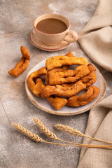 Crunchy biscuit Brushwood cookies on brown concrete, linen textile, cup of coffee, side view, close up
