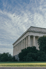 Obraz premium Lincoln Memorial with greenery and airplane overhead