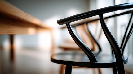 Wooden chairs sit elegantly next to a light-colored wooden table, softly lit room