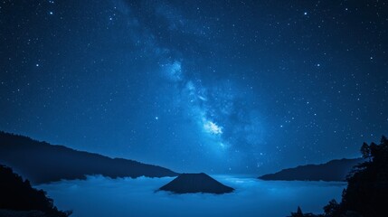 Night sky with Milky Way over a volcanic mountain and clouds