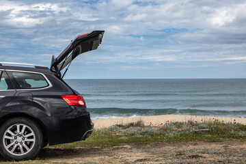Black car stoped on the Drivers' Beach with sandy beach and tranquil waves near to Sozopol, Burgas, Bulgaria