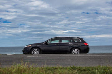 Fototapeta premium Black car stoped on the Drivers' Beach with sandy beach and tranquil waves near to Sozopol, Burgas, Bulgaria