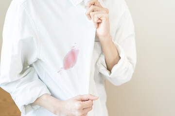 Dirty sauce stain cloth, asian young woman, girl wearing white shirt showing making on her cloth stain, spot dirty or smudge on clothes for cleaning before washing, maid female working at home concept
