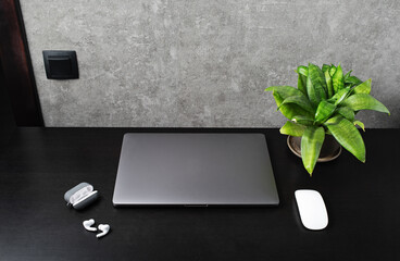 Office workspace with supplies and gadgets on black wooden table.