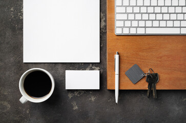 Real estate concept. Blank business card, coffee cup, key, keyboard, pen and paper. Flat lay.