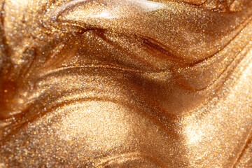 Glowing golden shimmering cosmetic texture of gel or body spray. Background texture for backdrops or mapping.
