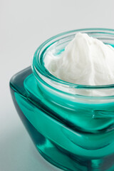 Jar of cosmetic cream on gray background. Moisturizing organic beauty cream. Hydrating natural skin care. Spa concept.