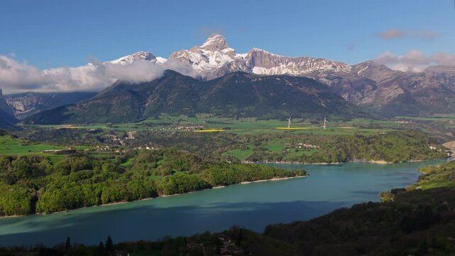Aerial view of Sautet Lake, wind turbines, and the higest point in the Devoluy mountain range, the Obiou peak. Morning near Pellafol. Isere, Alps, France