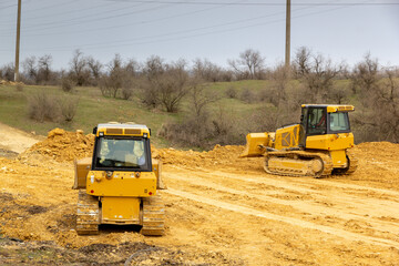 Bulldozers level and compact the ground for road construction
