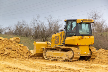 Bulldozer on road construction. Leveling and compacting the ground, paving. New road