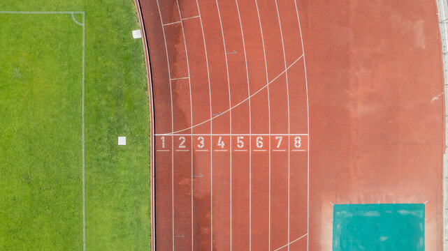 Aerial view of the Manuela Machado Municipal Stadium in Viana do Castelo, Portugal. Eight empty red tracks for running sports with tartan track of synthetic rubber on the athletic stadium.