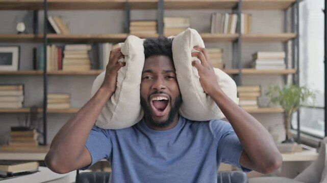 Stressed person with insomnia covering himself with his pillow.