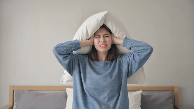 Stressed person with insomnia covering himself with his pillow.