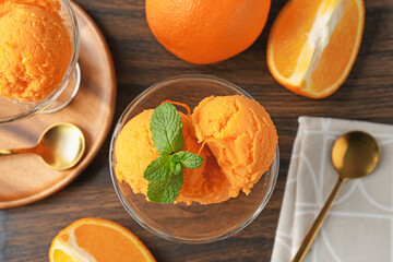 Tasty orange sorbet, fresh fruits and mint on wooden table, flat lay