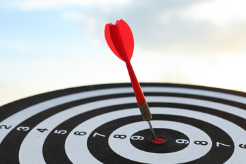 Targeting. Dart board with arrow outdoors, closeup