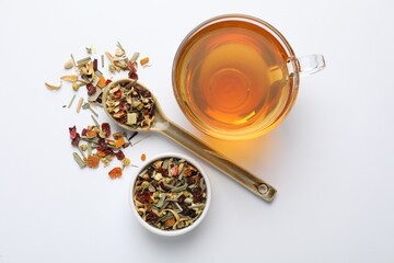 Delicious herbal tea and dry leaves on white background, top view