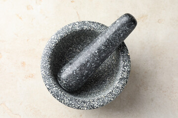 Stone mortar and pestle on light table, top view