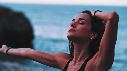 Young woman enjoying a mindful moment by the ocean, standing with arms wide open and eyes closed in deep serenity. Ideal for campaigns about self-empowerment, emotional healing, personal freedom
