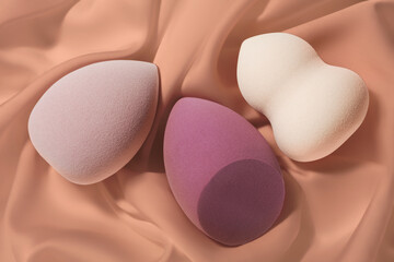 Beauty tools. Group of three make up blender applicators different form on foundation background
