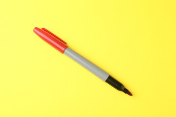 One red marker on yellow background, top view
