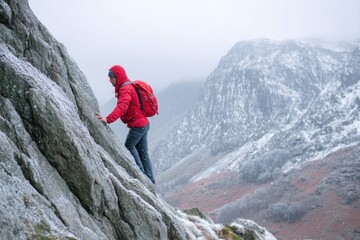 Obraz premium A climber scales a rugged and icy mountain during winter, demonstrating perseverance in harsh weather while surrounded by stunning natural scenery