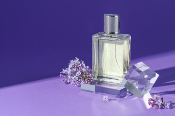 Stylish presentation of perfume bottle and lilac flowers on purple background, closeup. Space for...