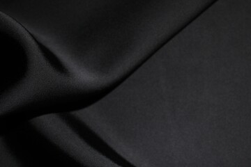 Obraz premium Crumpled black silk fabric as background, top view
