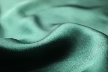 Crumpled green silk fabric as background, closeup