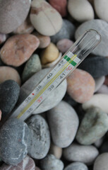 The tip of the thermometer is immersed in rocky soil. Global heating theme stock photo
