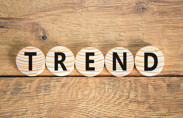 Fototapeta premium Trend and trending symbol. Concept word Trend on beautiful wooden circles. Beautiful wooden table wooden background. Business lifestyle trend and trending concept. Copy space.