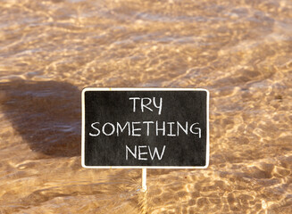 Naklejka premium Try something new symbol. Concept words Try something new on beautiful blackboard. Beautiful Red sea water background. Business motivational lifestyle try something new concept. Copy space.