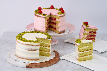 Pistachio & Raspberry Cakes and slice with Rose Butter cream, pink and white frosting side view of elegant desserts