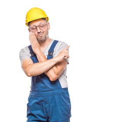 Whispering concept, construction worker holding hand near mouth and telling secret.Copy space, isolated on white background. Craftsman against white wall