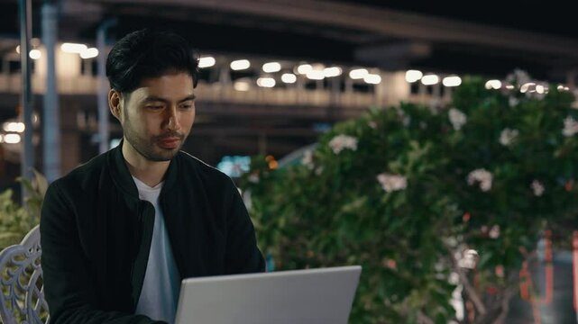 Concentrated distant manager using portable computer for communication with colleague in online chat. Stylish digital marketer working on pr strategy while sitting on summer terrace of cafeteria.