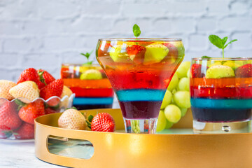 Homemade layered rainbow fruit jelly with fresh fruit