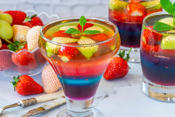 Homemade layered rainbow fruit jelly with fresh fruit