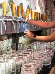 Bartender pouring craft beers at a small,upmarket and intimate city bar.