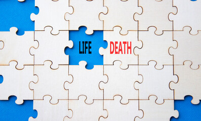 Life or Death symbol. Concept word Life or Death on wooden puzzle. Beautiful blue background. Business and Life or Death concept. Copy space