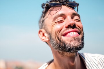 Man smiling with sunglasses enjoying a sunny day outdoors in a vibrant urban setting