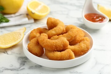 Tasty tempura shrimps and lemon on white marble table, closeup