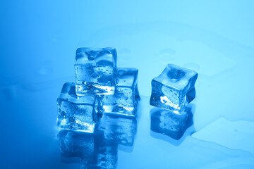 Cubes of clear ice on light blue background, closeup