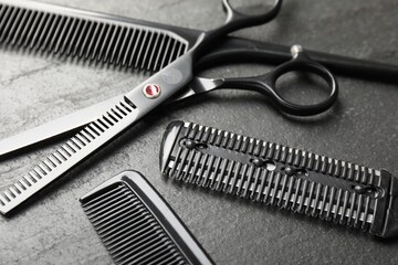 Different barber's tools on black table, closeup