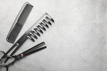 Different hairdresser's tools on grey table, flat lay. Space for text