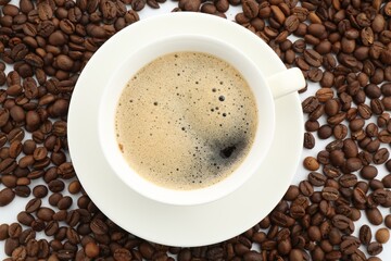 Aromatic coffee in cup and beans on white background, flat lay
