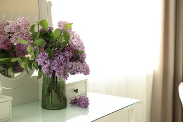 Beautiful lilac flowers in vase on dressing table indoors, space for text