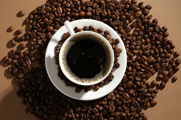 Aromatic coffee in cup and beans on beige background, flat lay
