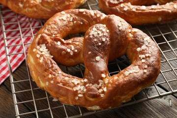 Tasty pretzels with salt on wooden table, closeup