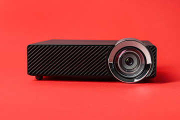Modern video projector on red background, closeup