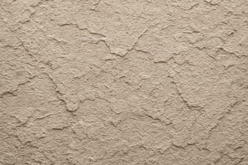 Close-up view of textured wall surface featuring a beige, rough finish