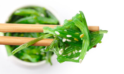 Chopsticks holding Japanese seaweed salad. Japanese cuisine - Wakame salad, Chuka seaweed salad